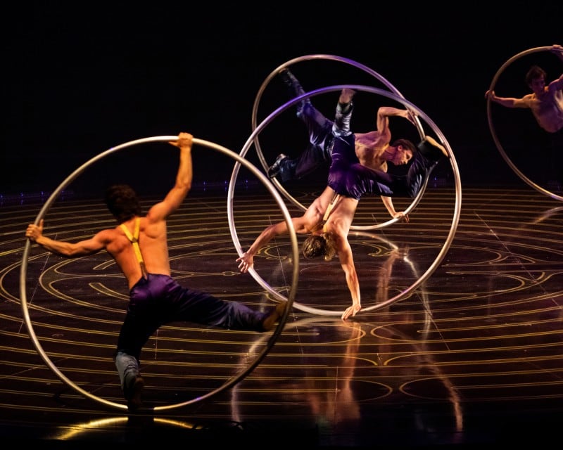 Four male acrobats performing a Cyr Wheel act.
